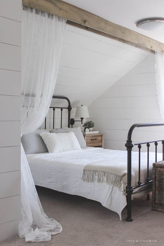 This cozy sleeping nook was created by adding a faux wood beam and lace curtains over the bed, and the results are amazing! See how to do this project in your home